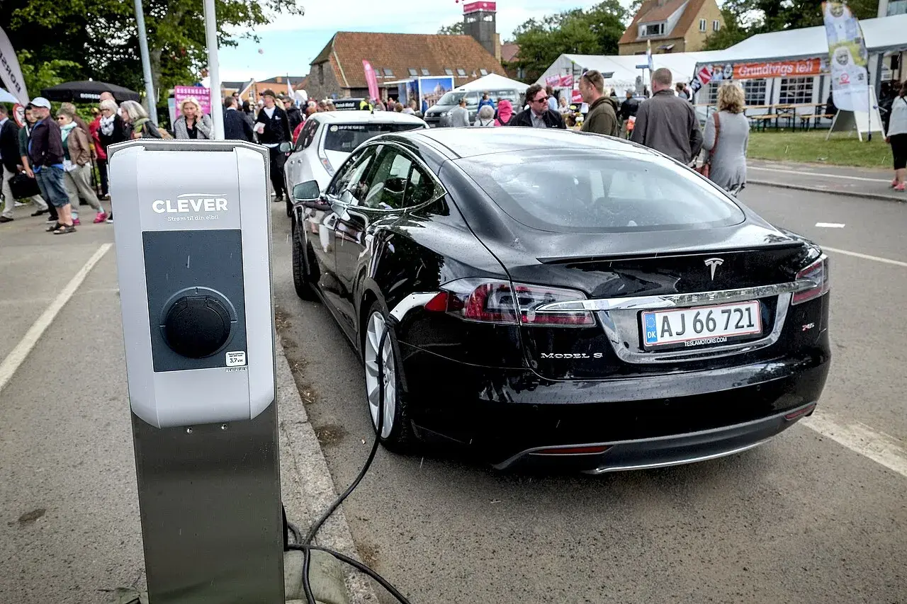 A black Tesla Model S electric car charging at a station in Bornholm, Denmark.
