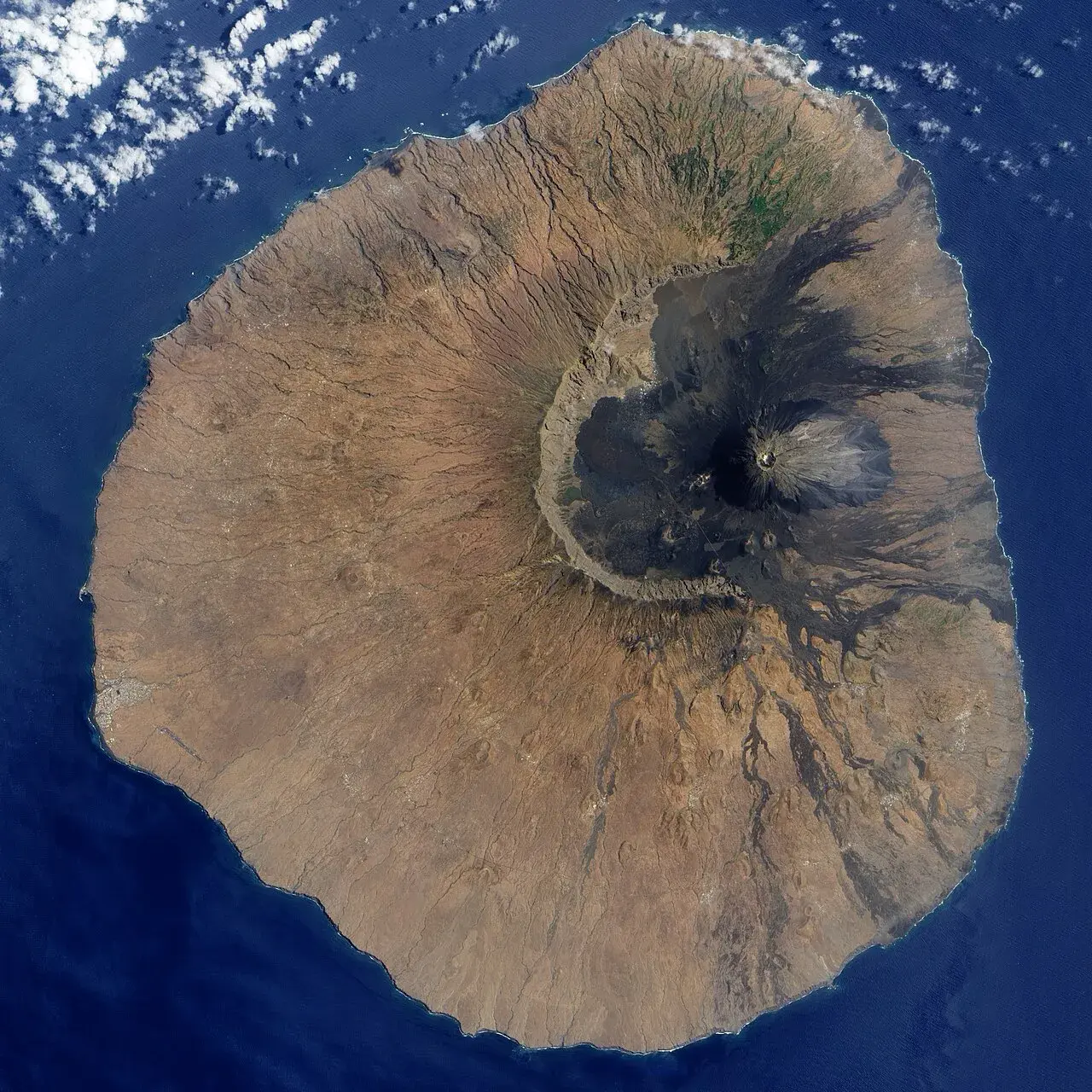 Udsigt over Fogo-øens Cha Caldera med den markante vulkankegle Pico i midten. Lavaaflejringer fra nyere udbrud ses som mørke spor ud mod Atlanterhavet.