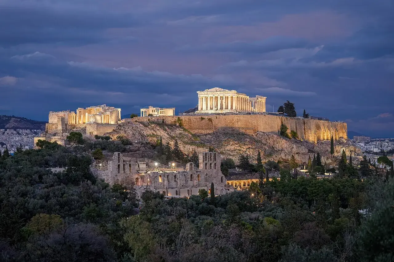 Akropolis i Athen oplyst om natten. Et stemningsfuldt billede af det historiske vartegn i mørke.