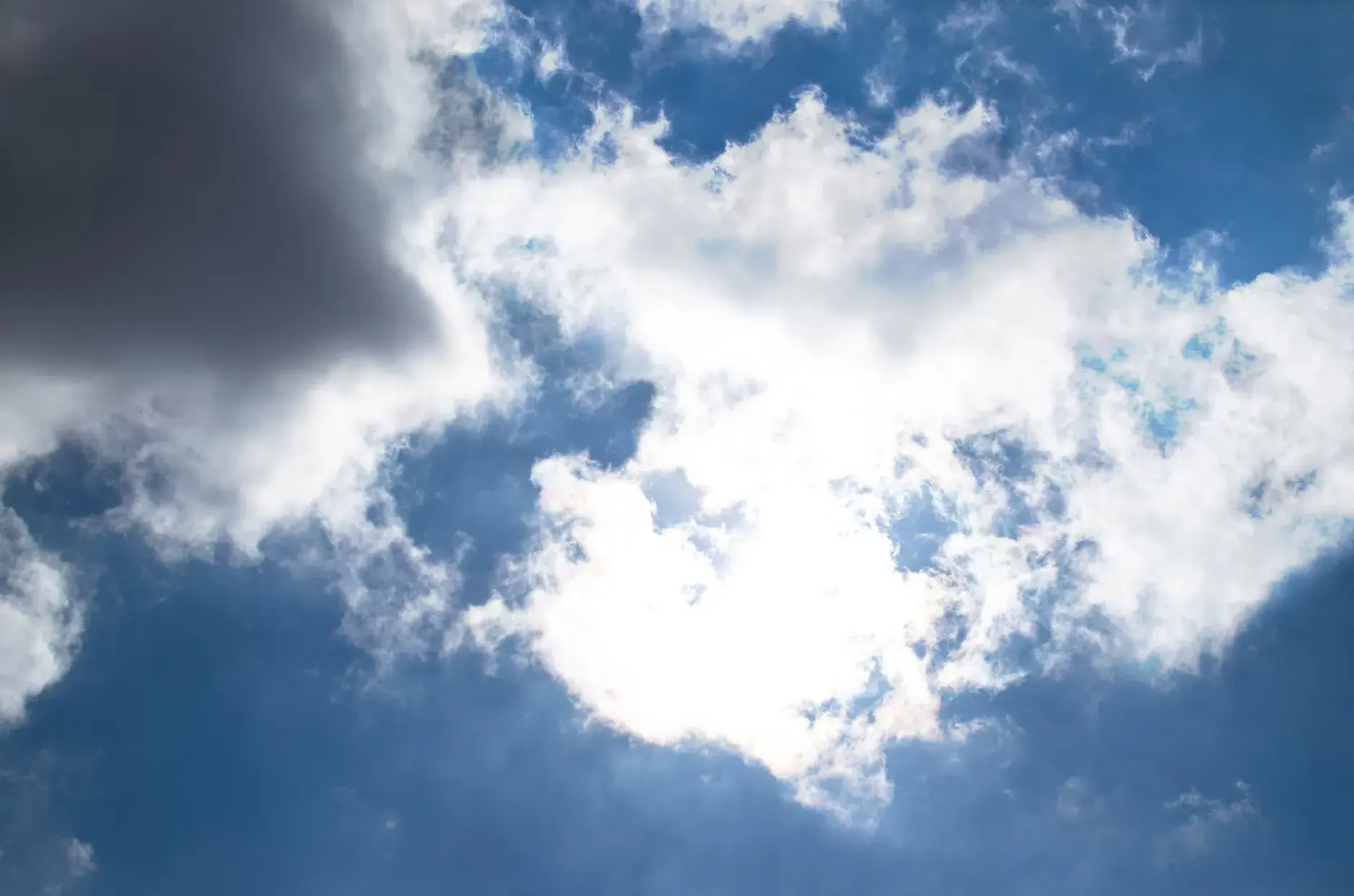 En farverig skyhimmel med store, fluffy skyer mod en dyb blå baggrund på en solrig dag. Stemningen er rolig og klar, med naturligt lys og høj kontrast.