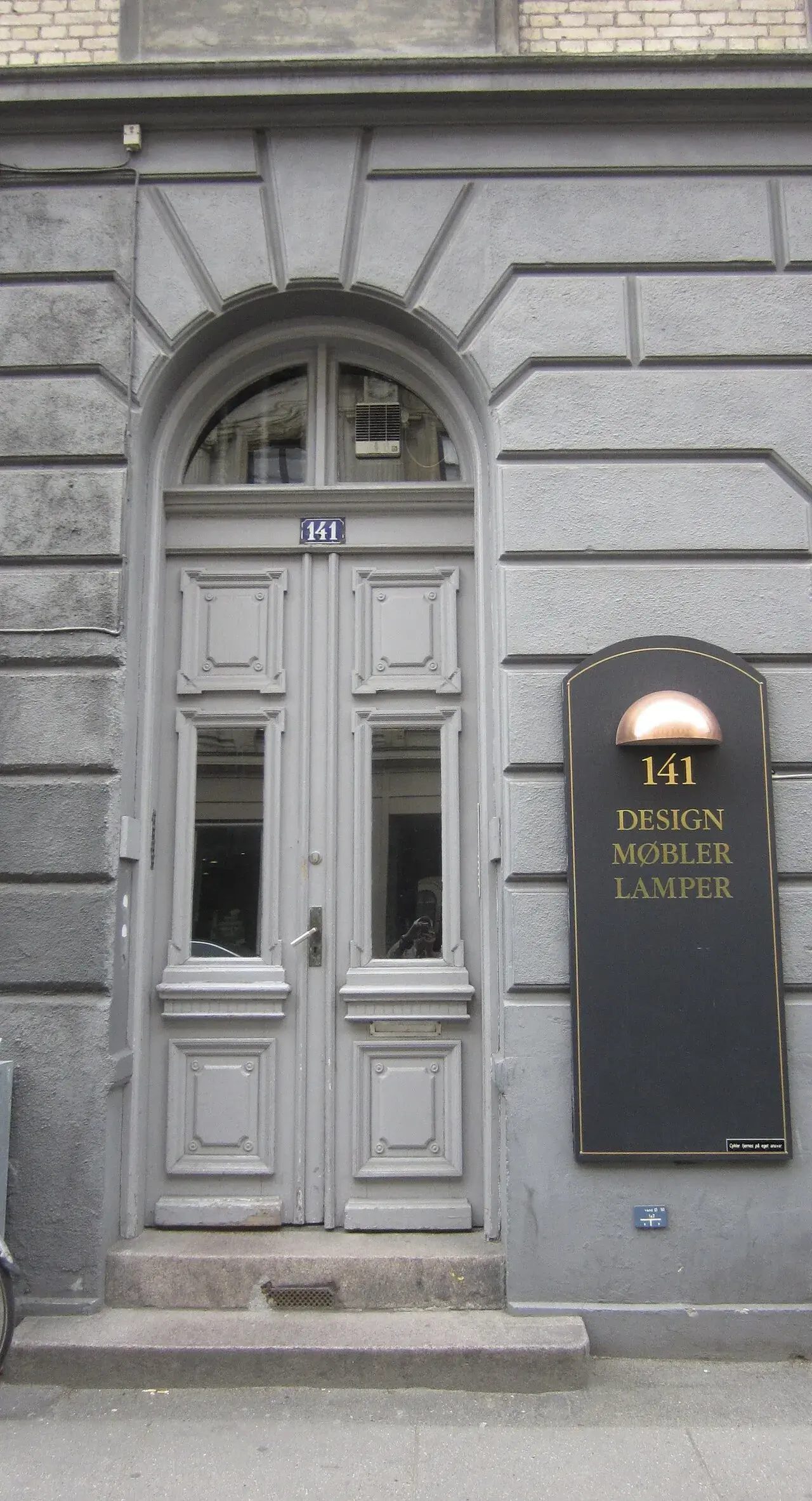 Bygningen på Gammel Kongevej 141 i København ses her i et historisk bymiljø. Et detaljepræget facadebillede med tydelig arkitektonisk karakter.