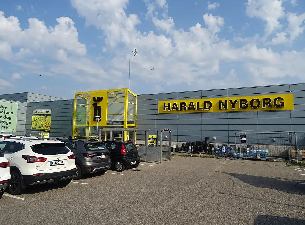 Facade og butikslokation for Harald Nyborg i Trekroner i Roskilde, Danmark. Billedet viser butiksmiljøet i dagslys.
