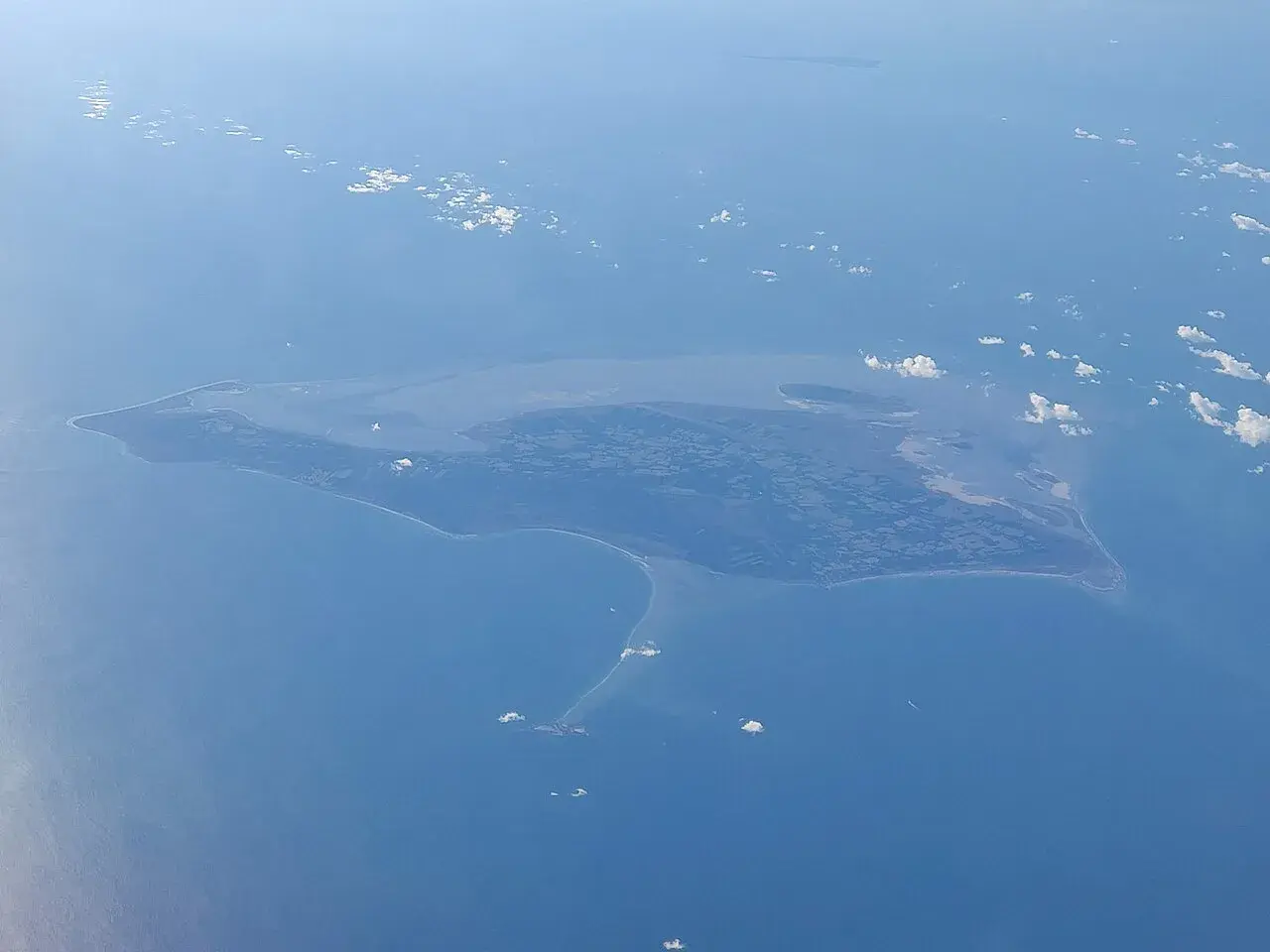 Luftfoto af Læsø, Danmark, taget fra nordvest. Perspektivet fremhæver øens landskab og kystlinje.