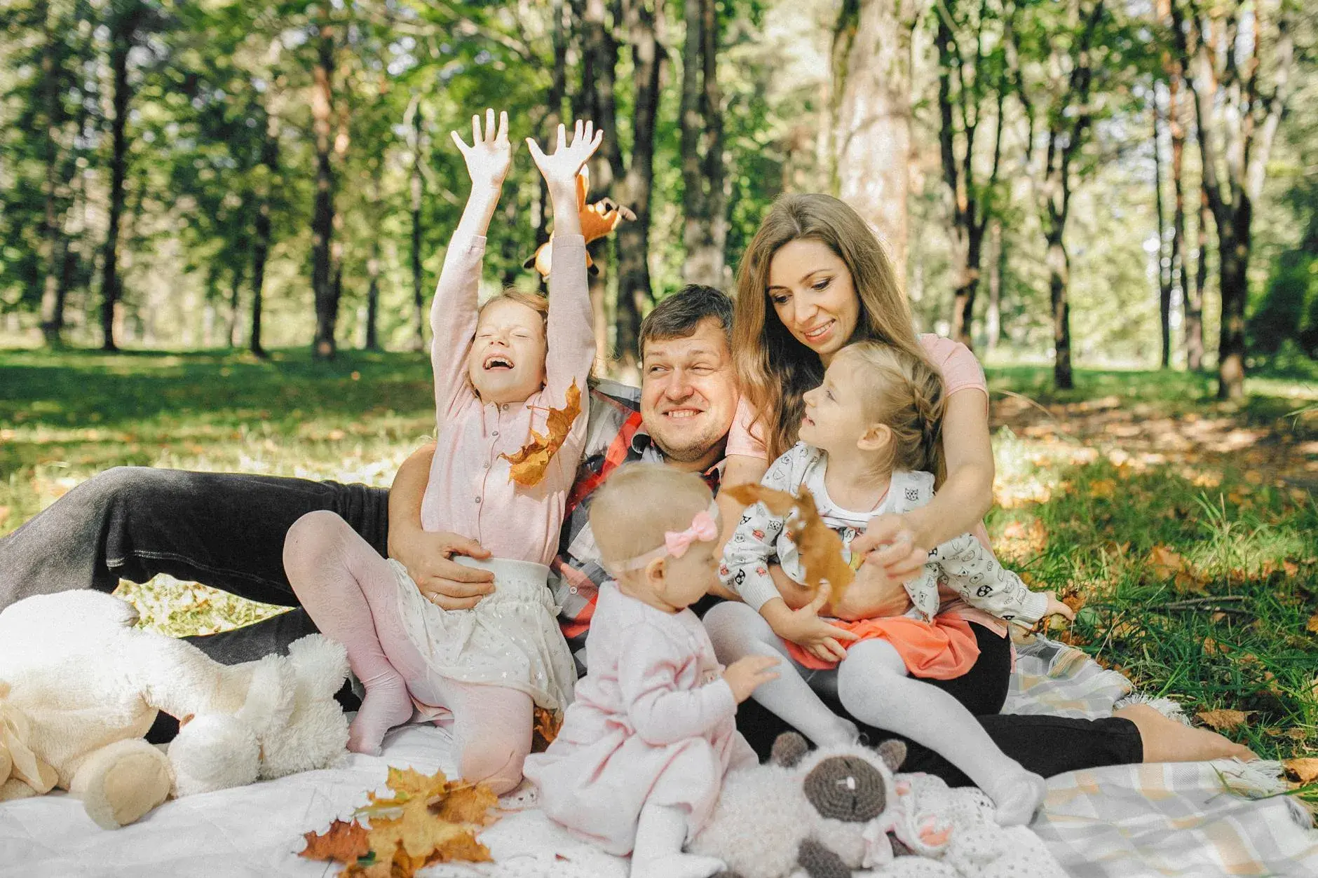 A joyful family spending quality time together in a sunny park setting.