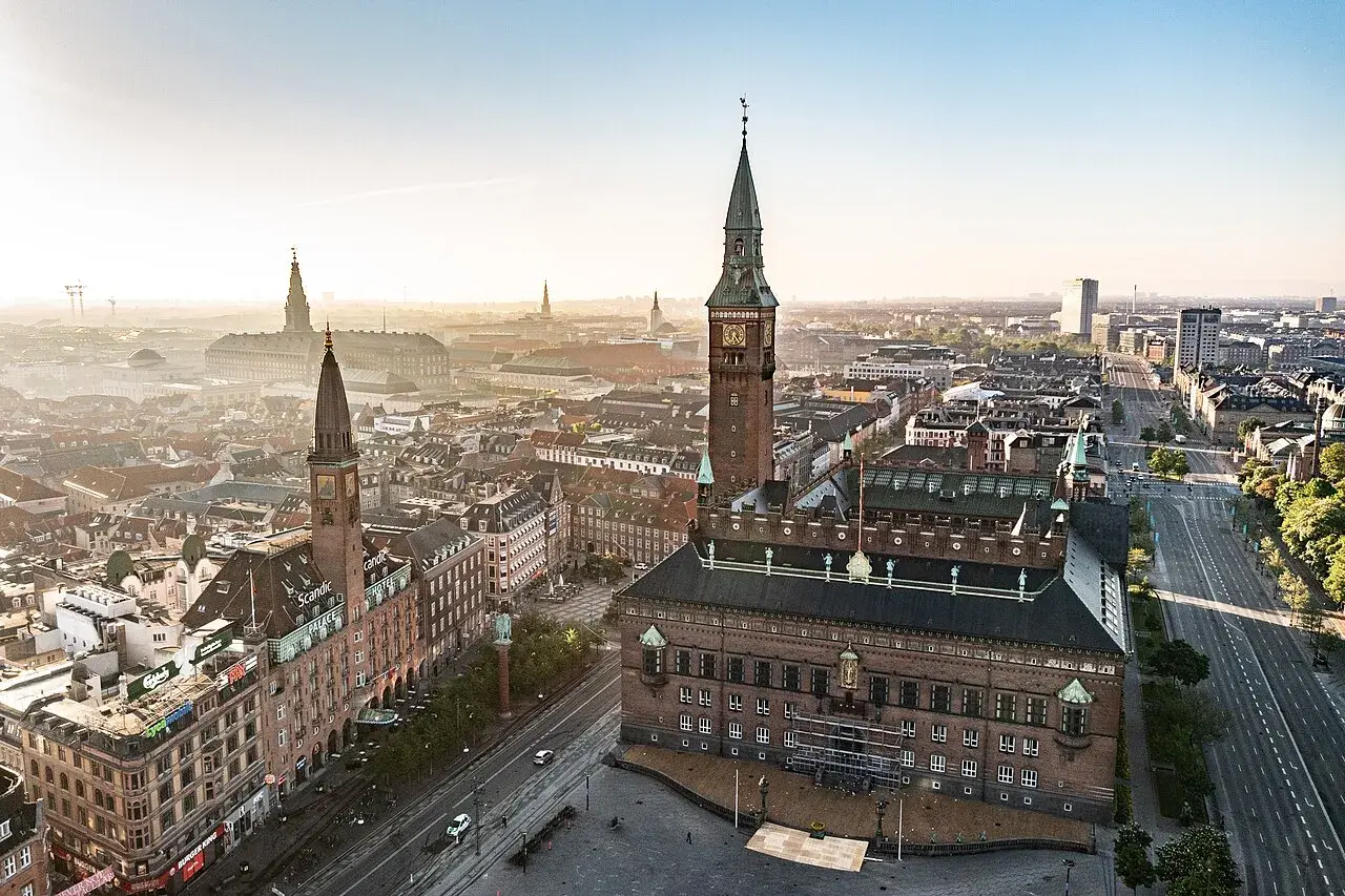 Et bredt udsyn til Københavns Rådhus på Rådhuspladsen omgivet af historisk byarkitektur. Billedet viser bygningen som et centralt byvartegn.
