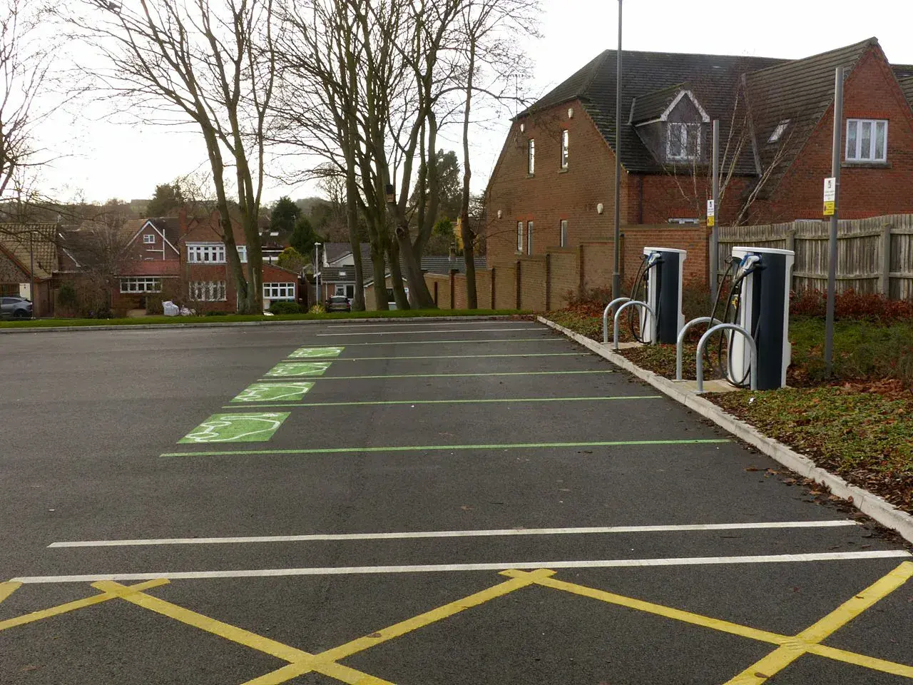 Et nærbillede af ladestandere til elbiler i en offentlig parkeringszone. Billedet fremhæver infrastrukturen for bæredygtig transport.