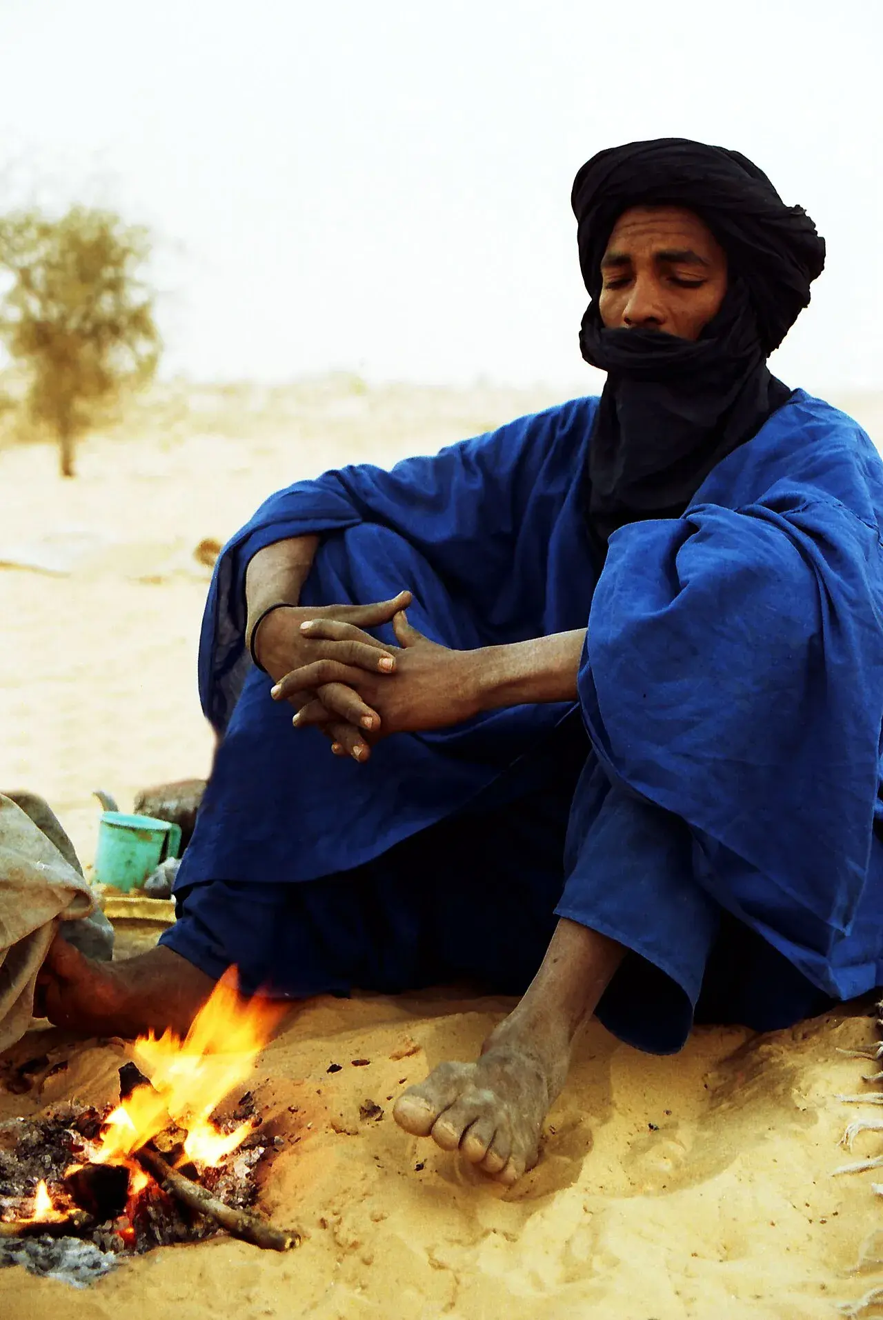 En Tuareg i det nordlige Mali tænder et bål for at lave te. Scenen er sat i Sahara-området og illustrerer hverdagsliv i ørkenen.