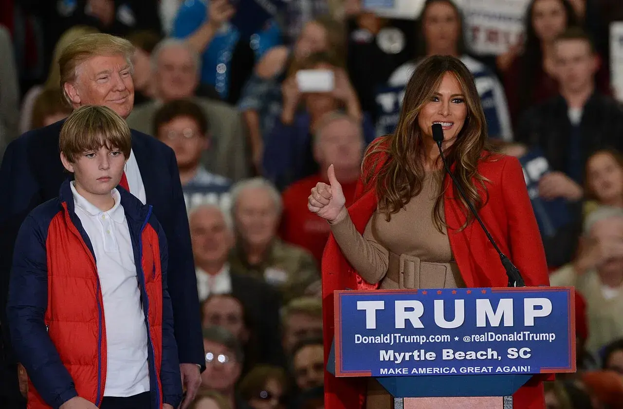 Melania Trump taler ved et kampagneevent for Donald Trump i 2015, mens Barron Trump ses sammen med sine forældre.