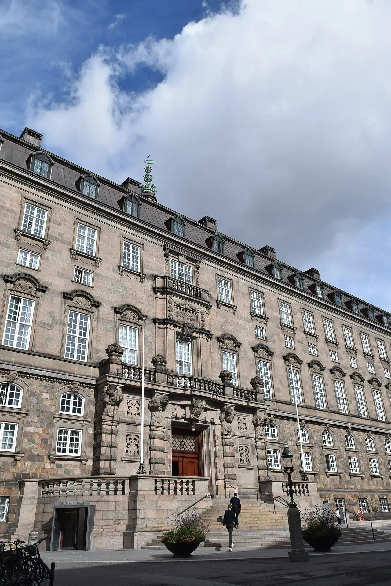 Facadefoto af Christiansborg Slot, også kendt som Folketingets bygning, i København. Billedet fremhæver bygningens markante arkitektur og rolle som dansk regerings- og parlamentarisk centrum.