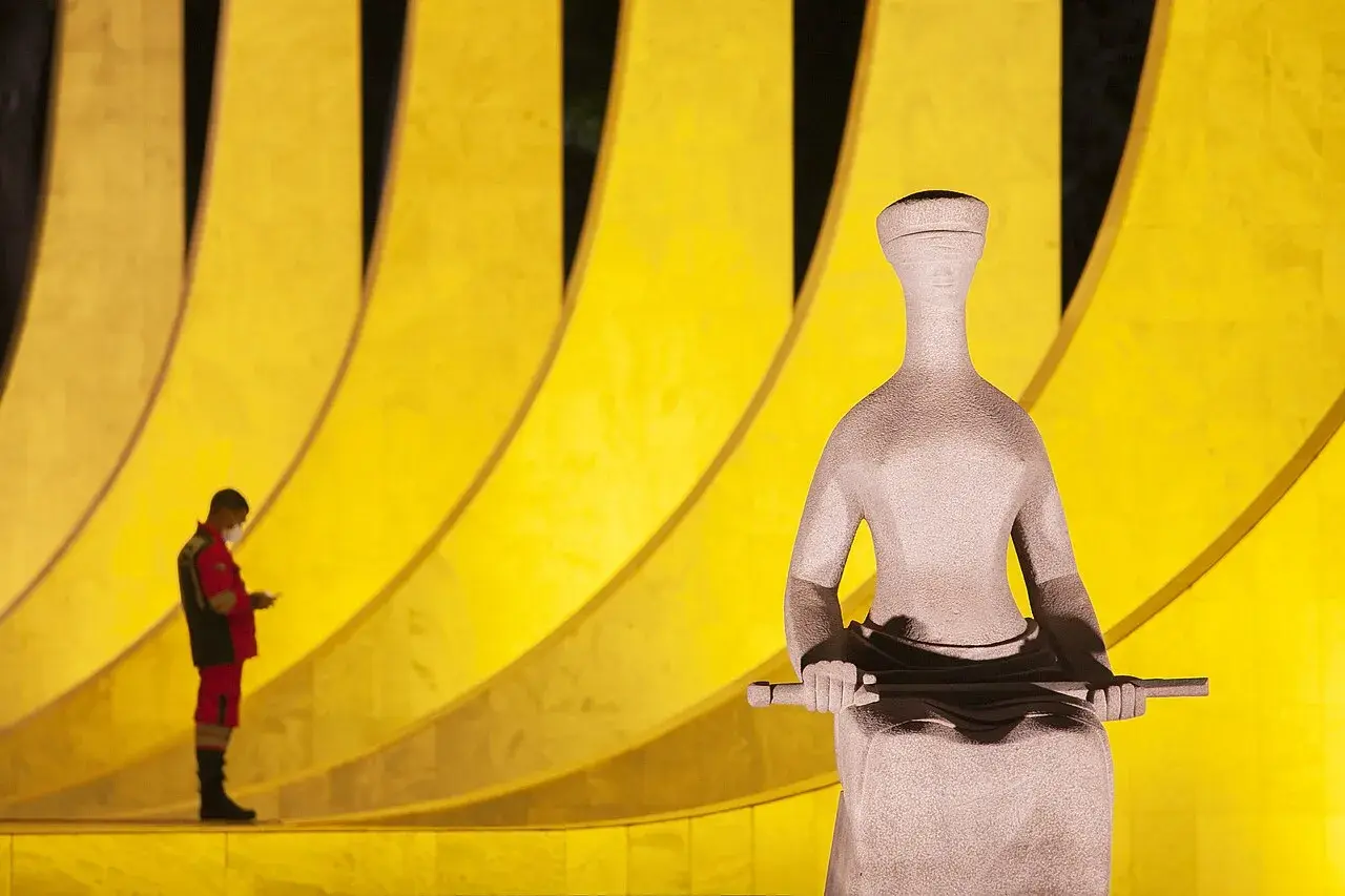 Supremo Tribunal Federal-bygningen i Brasilia ses sammen med en statue på Praça dos Três Poderes. Billedet viser en del af Brasílias ikoniske regeringsområde.