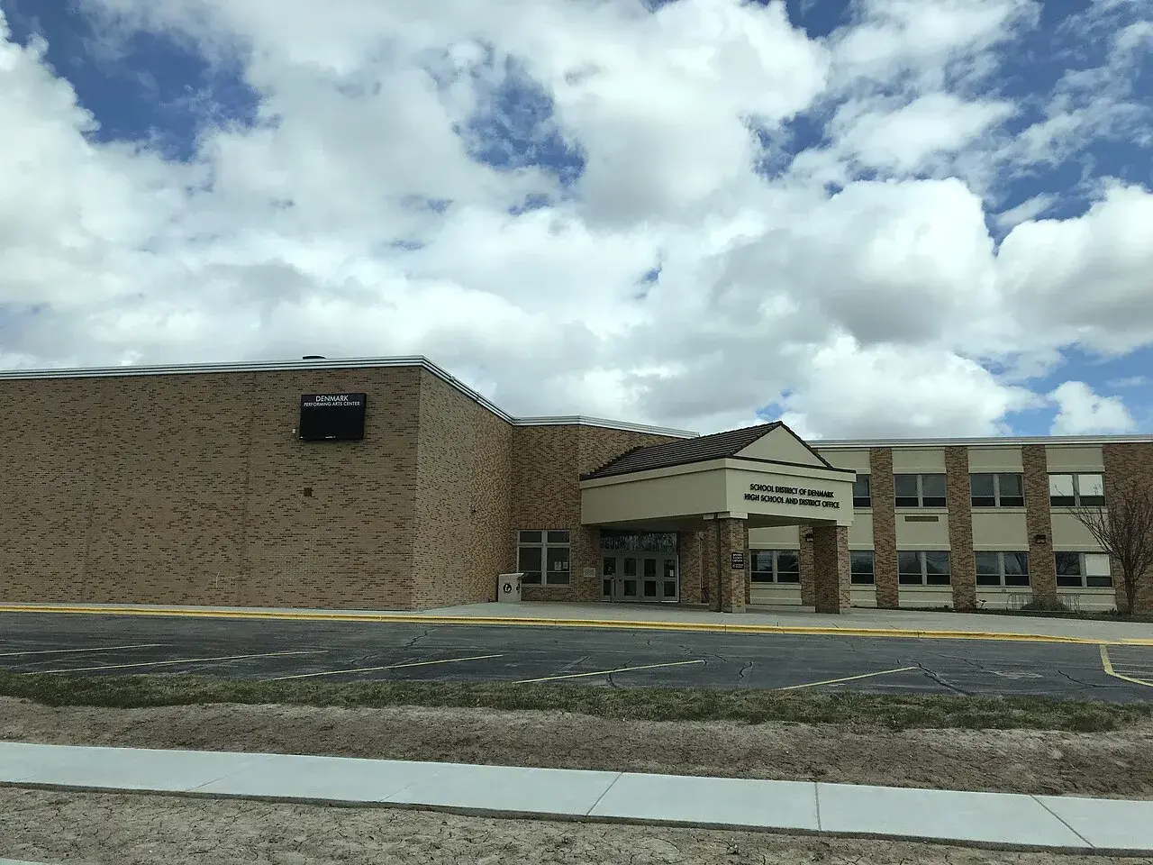 Fotografi af hovedindgangen til Denmark High School i Denmark, Wisconsin. Billedet viser skolens facade og indgangsområde.