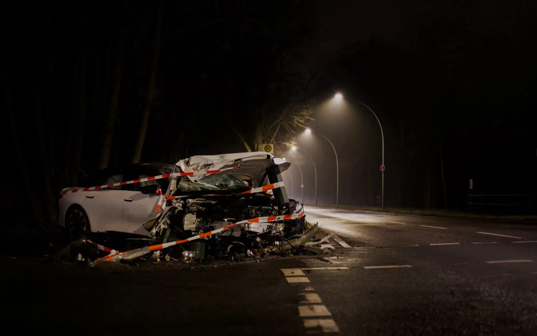 En rød bil er væltet over på en sort bil i en udendørs scene. Billedet viser et dramatisk øjeblik fra en bilkrasch.