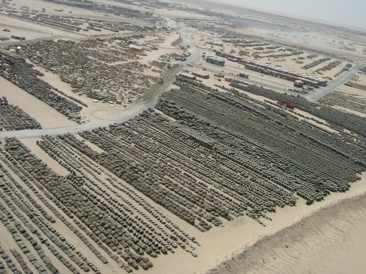 Tusindvis af dæk og andet udstyr på en opbevaringsplads på Camp Arifjan i Kuwait. Stort set alle køretøjer og kampudstyr, der losses fra MSC-skibe i Port of Ash Shuaybah, gør holdt på Camp Arifjan, før de sendes til deres endelige destination i Mellemøsten.