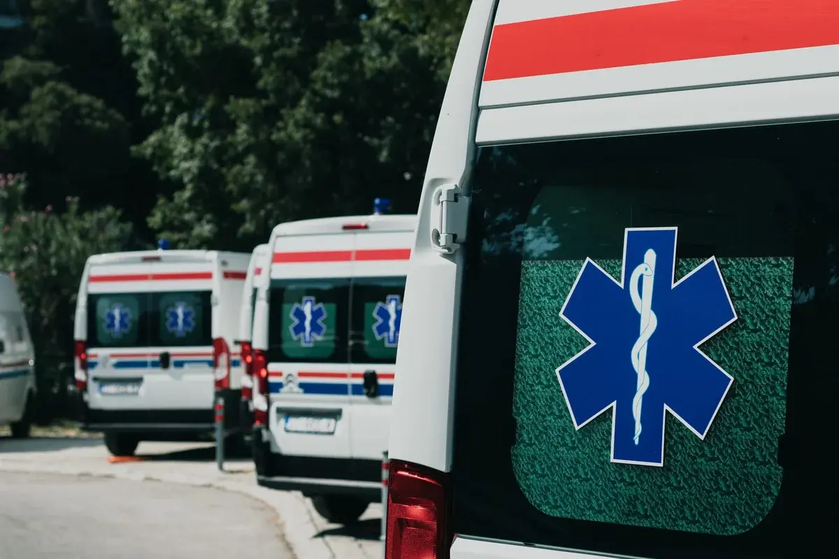 Three ambulances parked outdoor with medical symbols