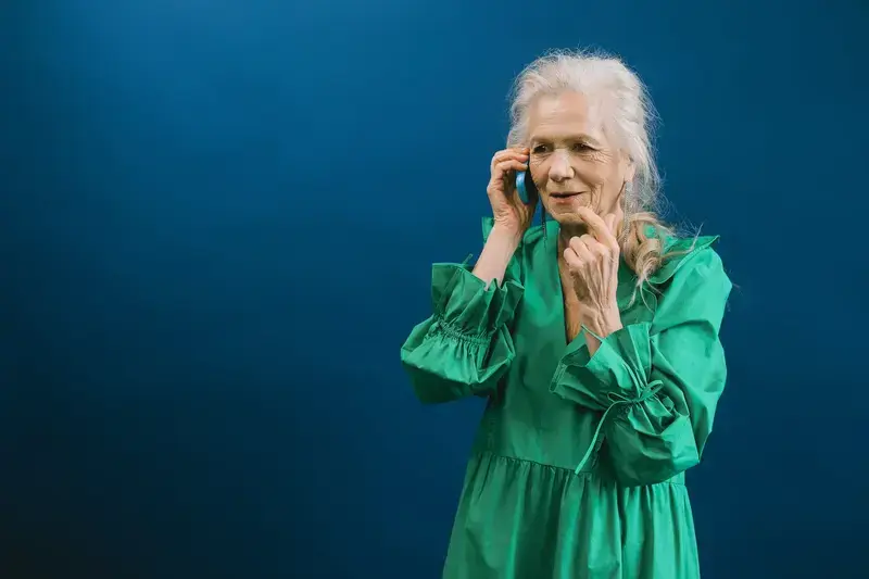 Senior woman in green dress talking on phone