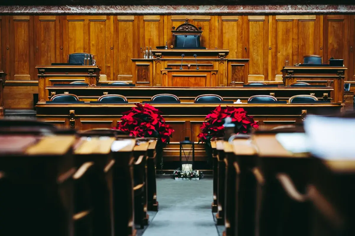 An empty wooden courtroom decorated with red poinsettias.