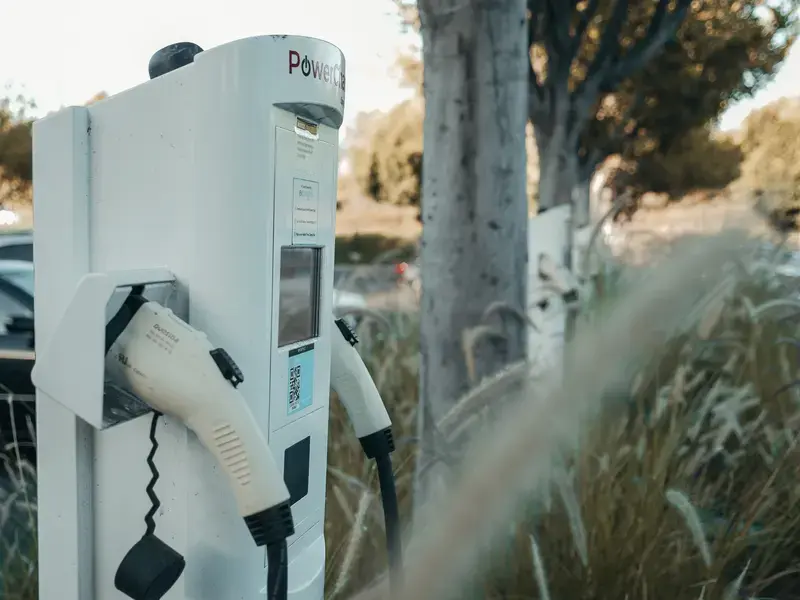 Electric vehicle charging station outdoors near plants and trees