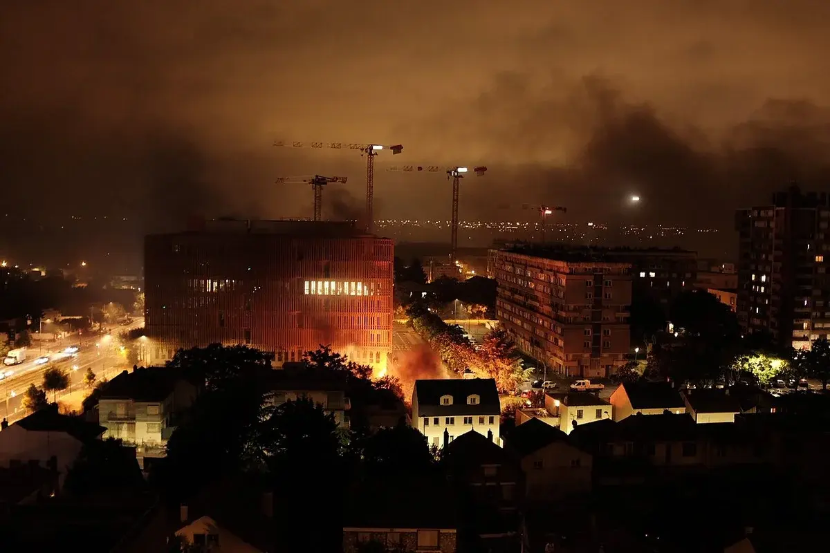 Nighttime scene of smoke and fire during unrest in Villejuif, France.
