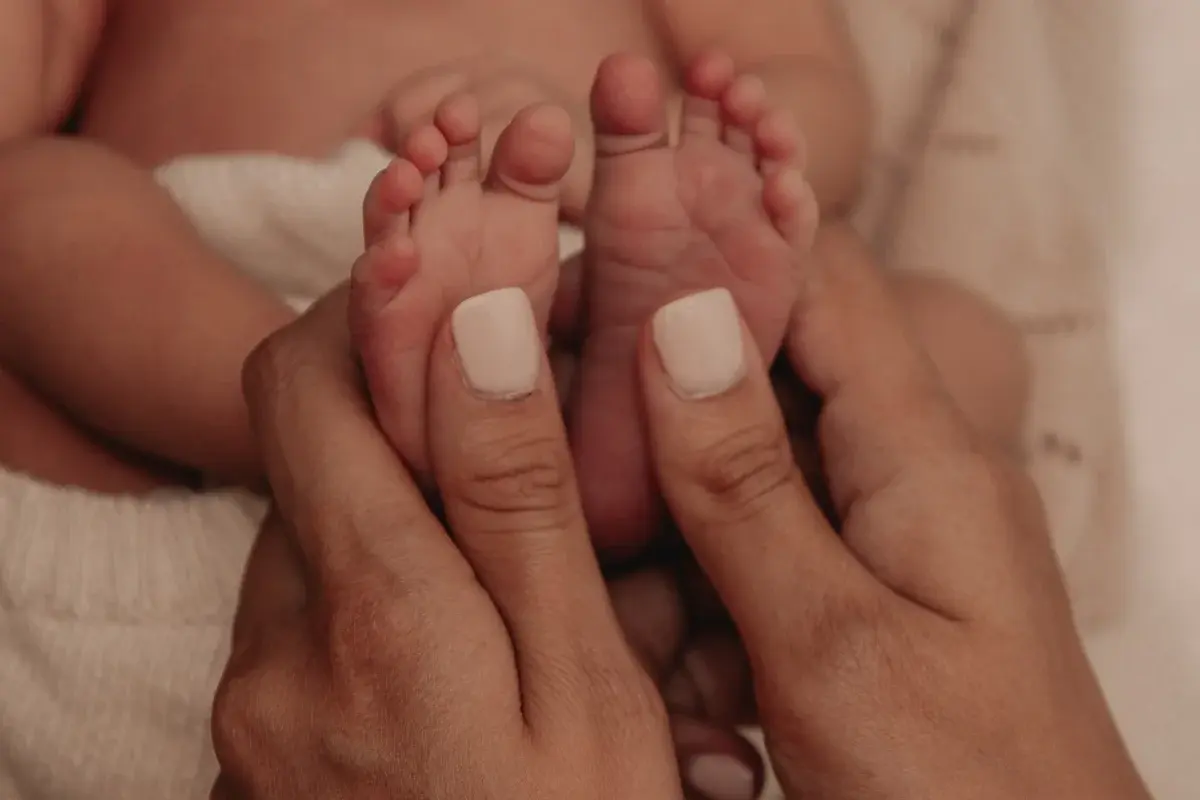 Close-up of a mother holding her newborn baby's feet.
