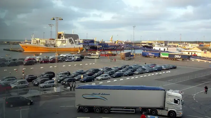 Port with ships, parked cars, and a truck