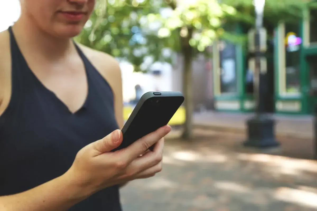 Close-up of a young woman using a smartphone outdoors.