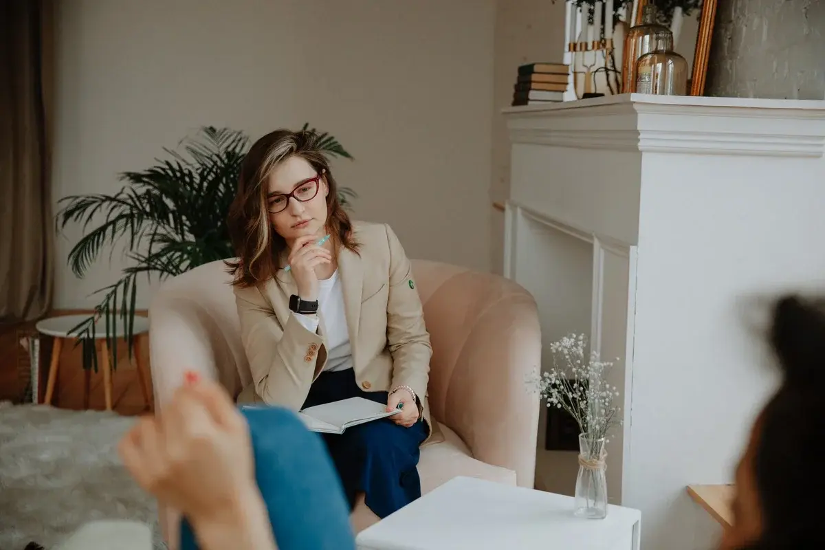 female therapist listening and taking notes during counseling