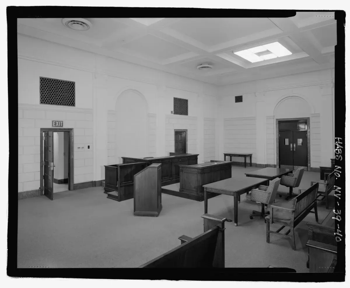 Black-and-white photo of an empty courtroom interior.