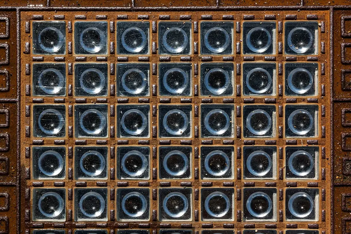Close-up of a patterned floor with square glass tiles.