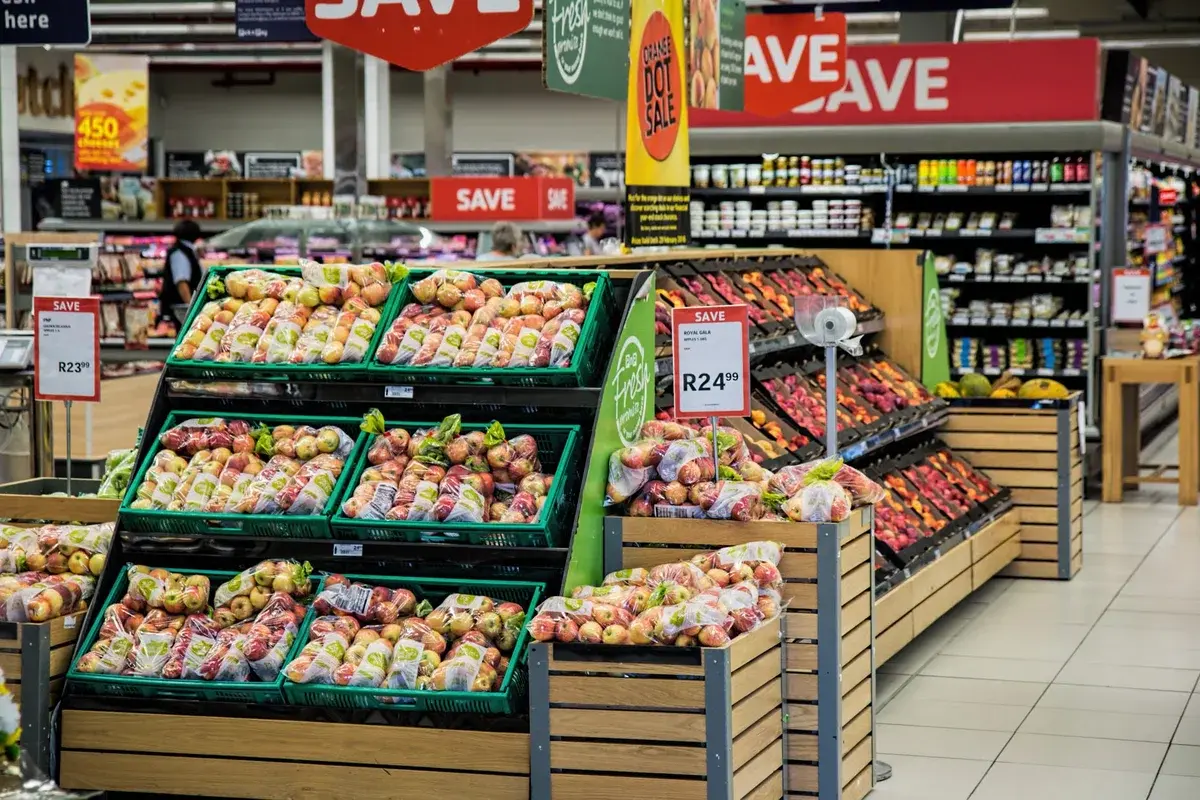 fruit aisle with apples and sale signs in supermarket