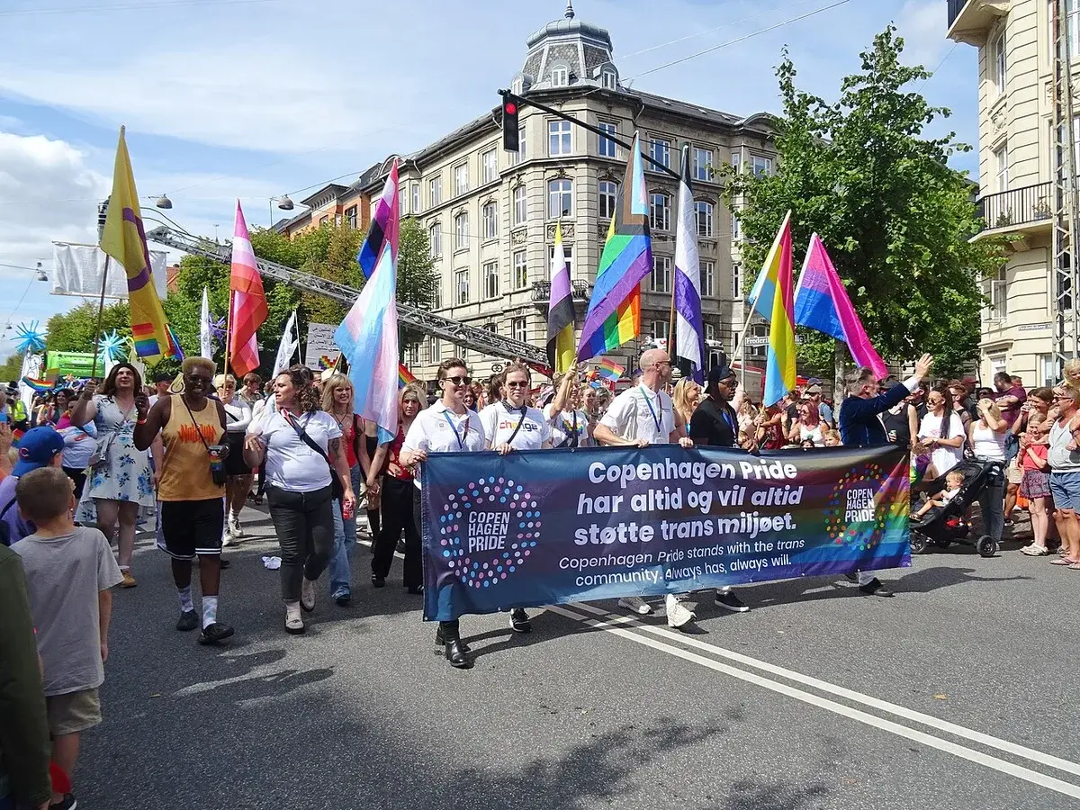 Participants in Copenhagen Pride Parade holding a banner supporting the trans community