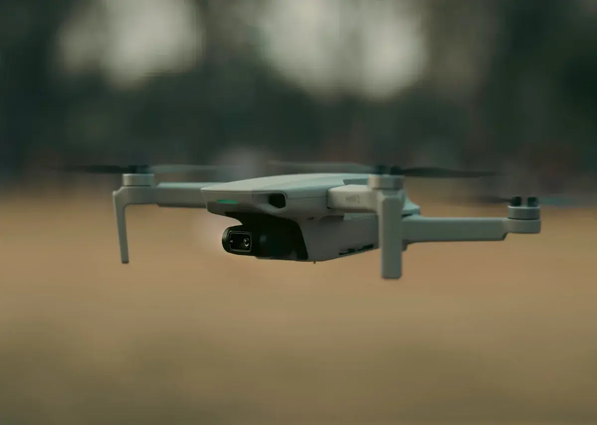 A drone hovering low over the ground outdoors.
