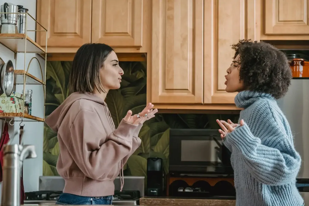 Two young women arguing in a kitchen
