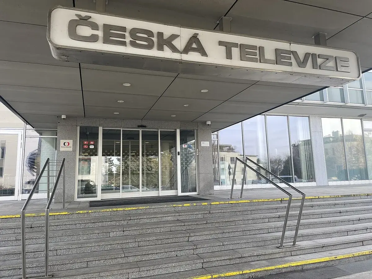 Main entrance of Czech Television building with glass doors and steps.