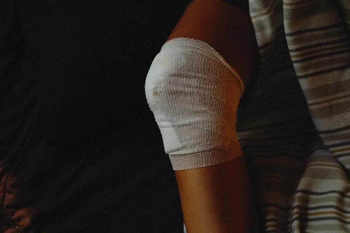 Close-up of a knee wrapped in a white bandage.