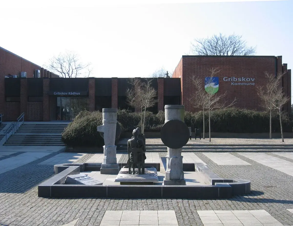 Gribskov Town Hall building with a plaza and sculpture fountain in front.