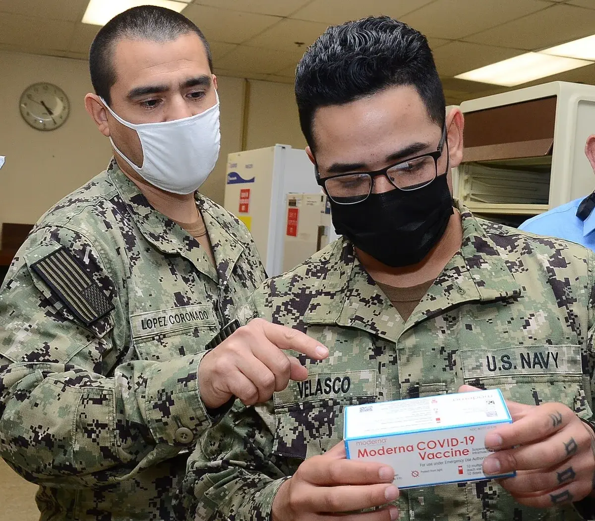 U.S. Navy personnel holding Moderna COVID-19 vaccine box