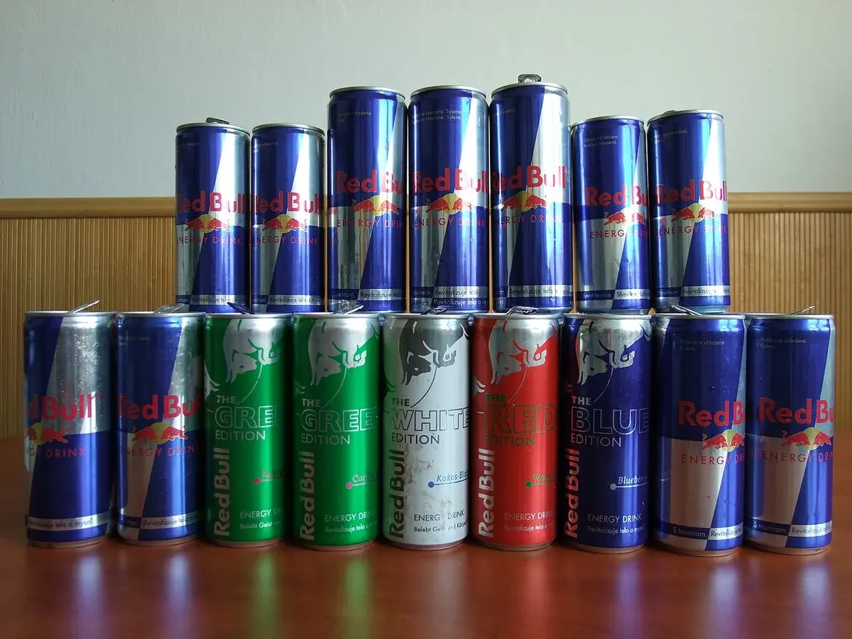 A row of Red Bull energy drink cans on a table.