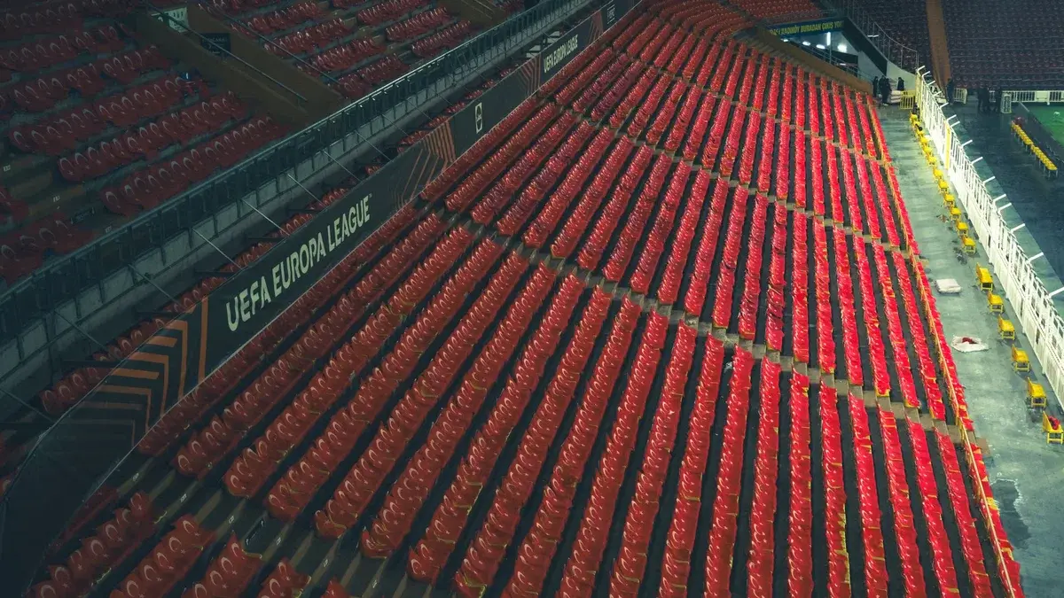 Rows of empty red seats in a stadium with UEFA Europa League branding.