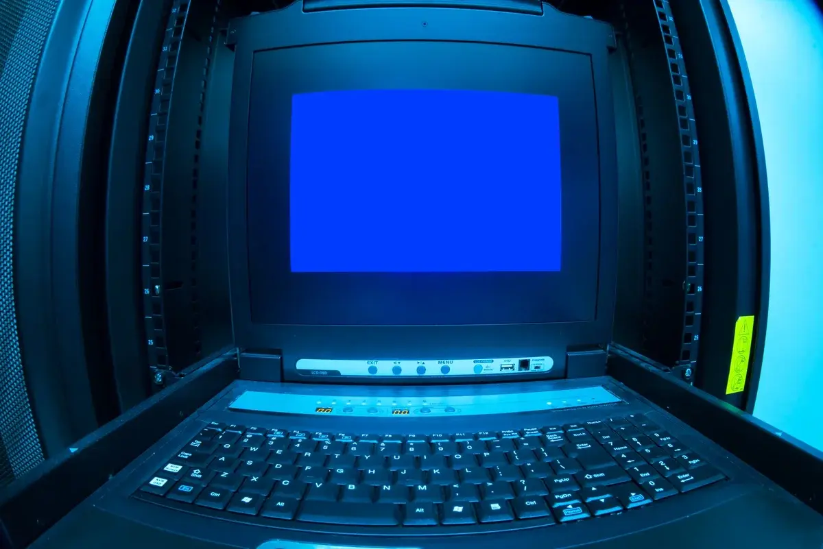 A computer terminal in a datacenter showing a blue screen error.