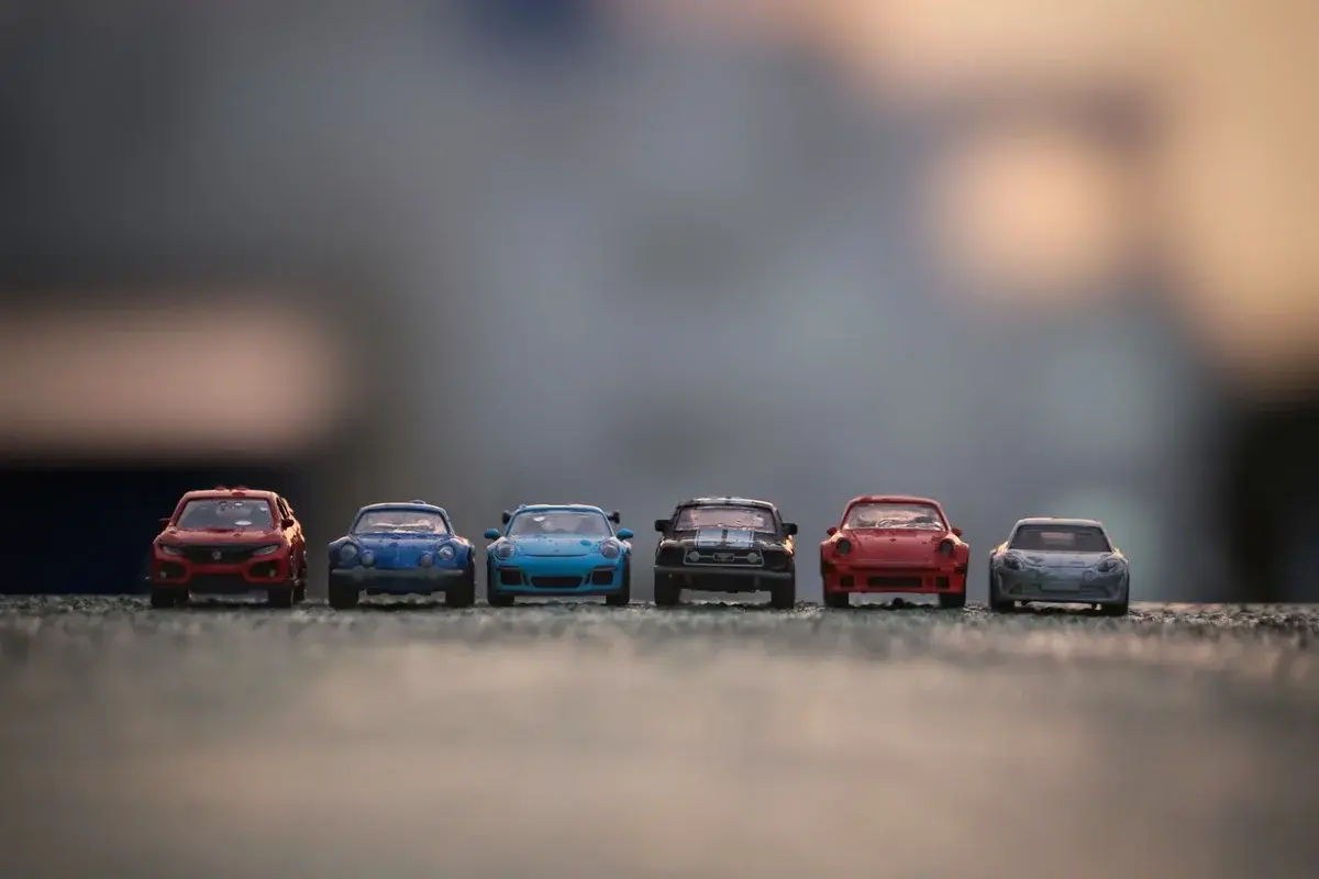Six toy racing cars on asphalt