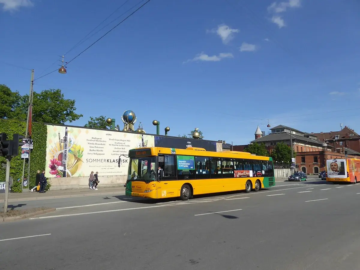 Yellow city bus stopped on Bernstorffsgade street with festival advertisement