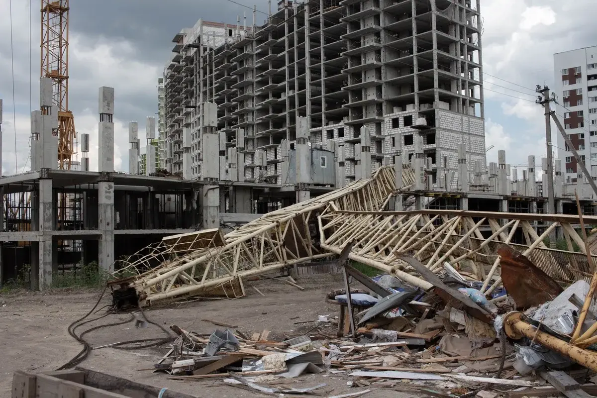 Collapsed crane at construction site with unfinished buildings