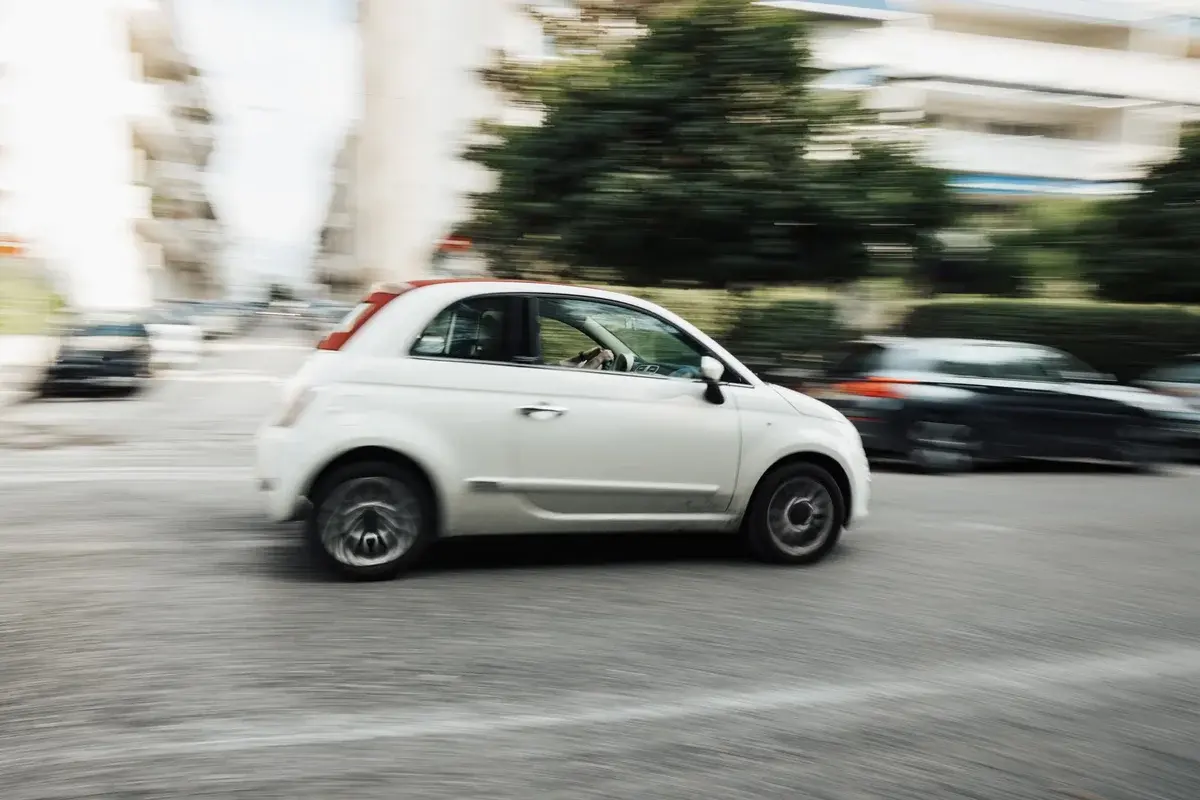 White car speeding on city street with motion blur