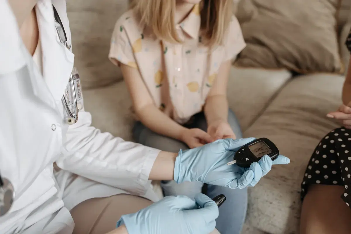 Doctor using a glucose meter to check a patient's blood sugar.