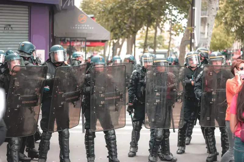 Soldiers in police uniforms with helmets and shields standing in formation