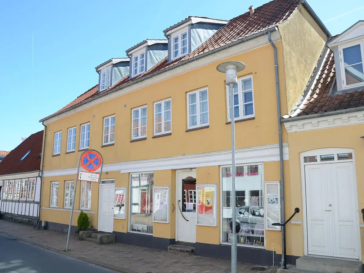 Yellow building housing Mødrehjælpen thrift shop on Langegade street