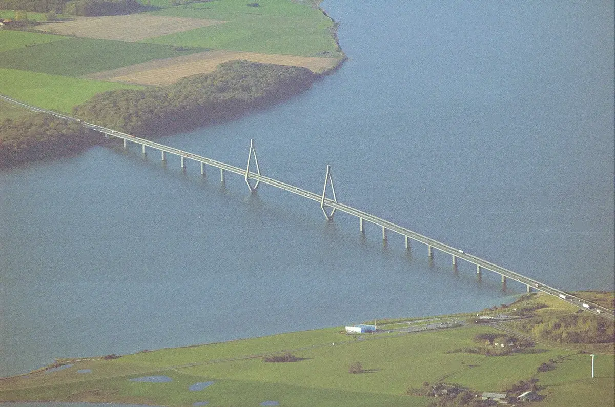 Aerial view of a bridge crossing water beside farmland.