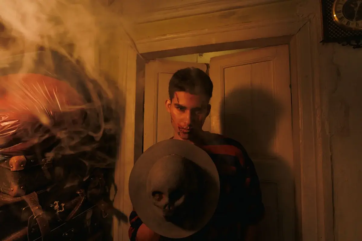 Man holding hat with skull in smoky room
