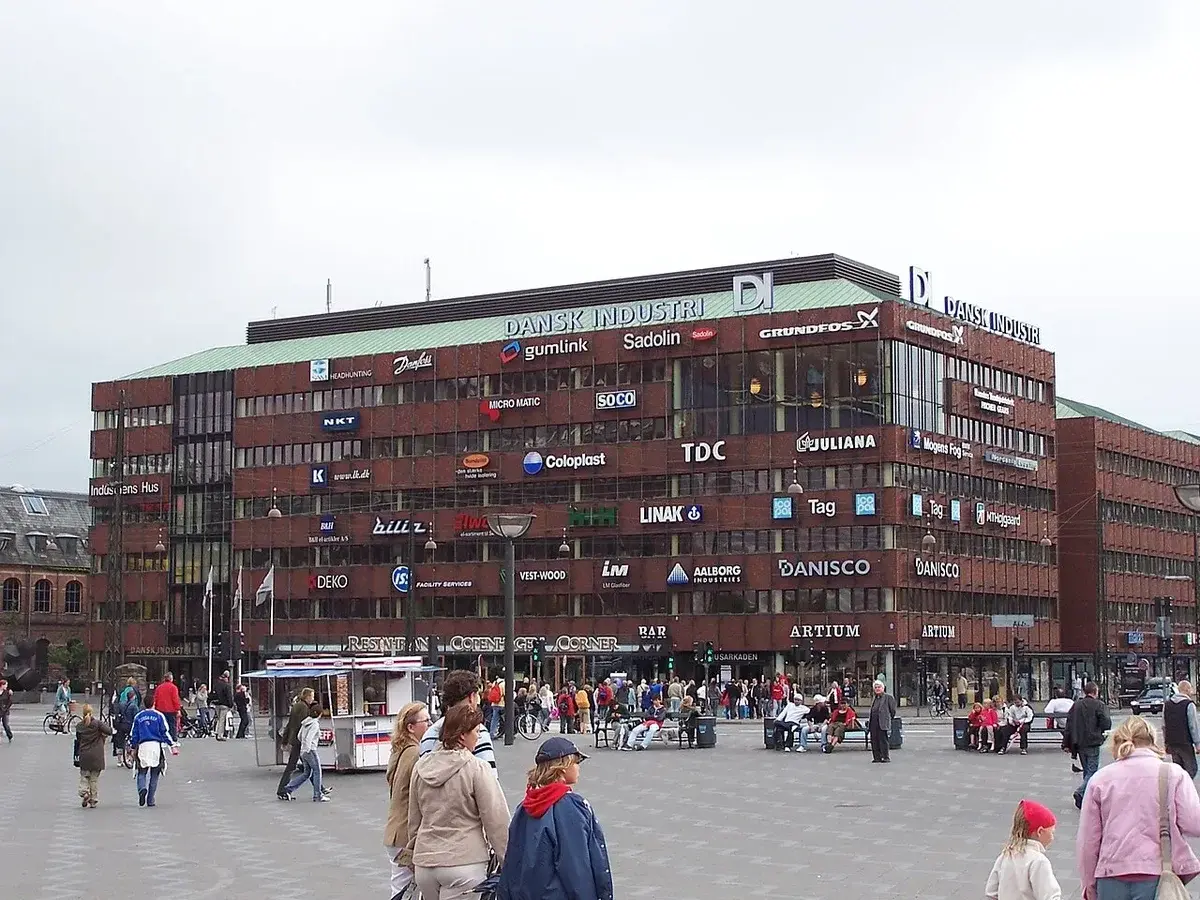 Large office building with Dansk Industri signage and people nearby