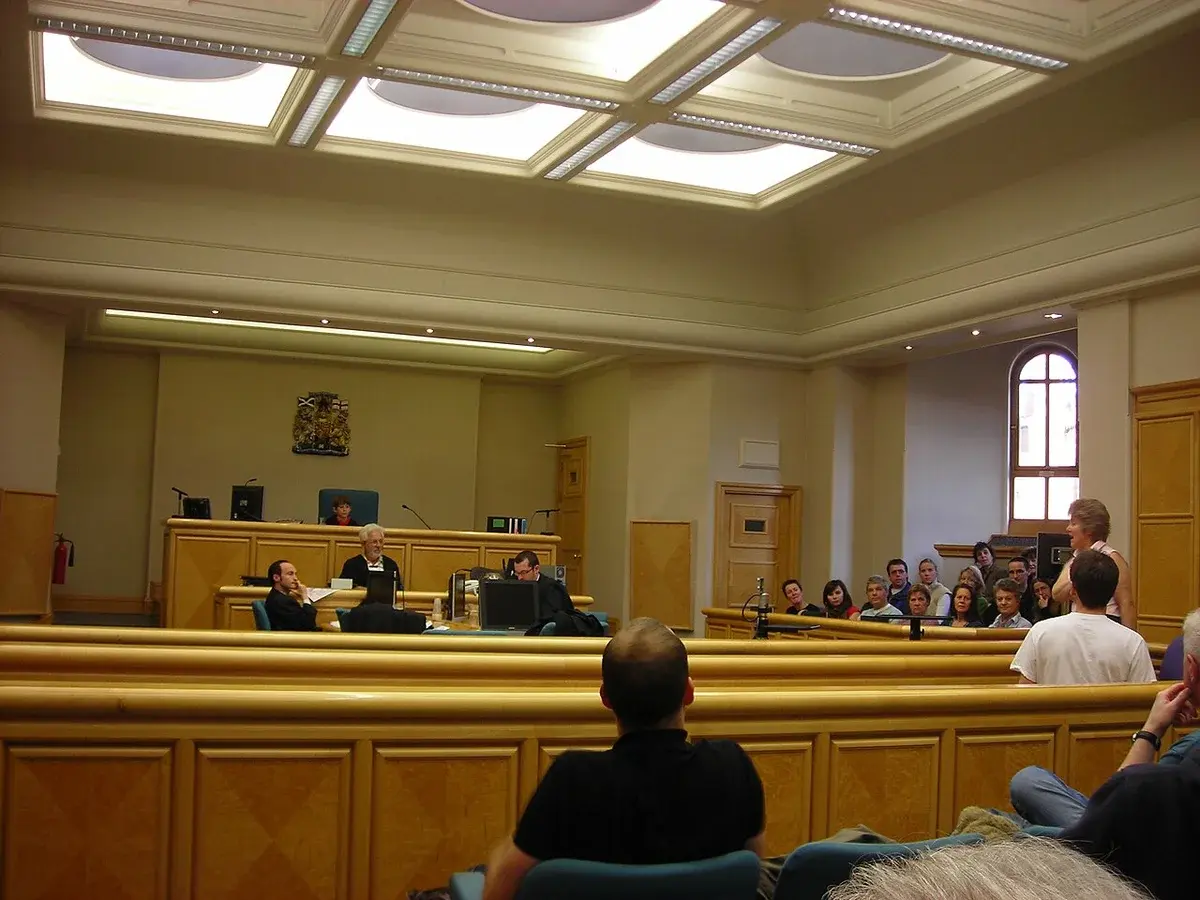 A courtroom in Edinburgh Sheriff Court with people seated and staff at the front.